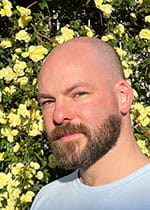 head shot of Ian Padykula in front of yellow roses