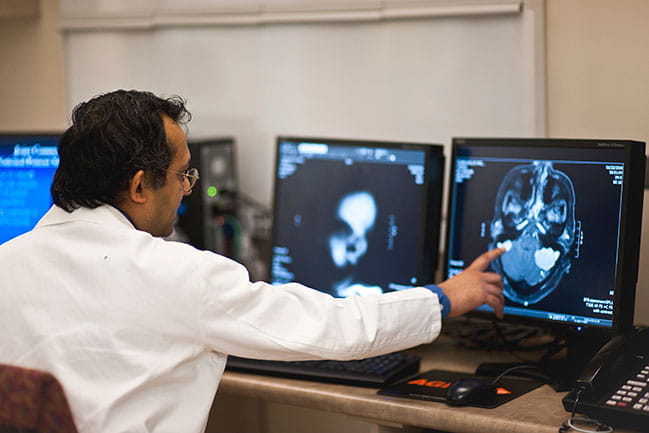 Dr. Sunil Patel reviewing scan on computer. 