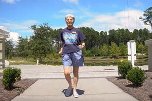 a woman walks in a retirement community on a sunny day
