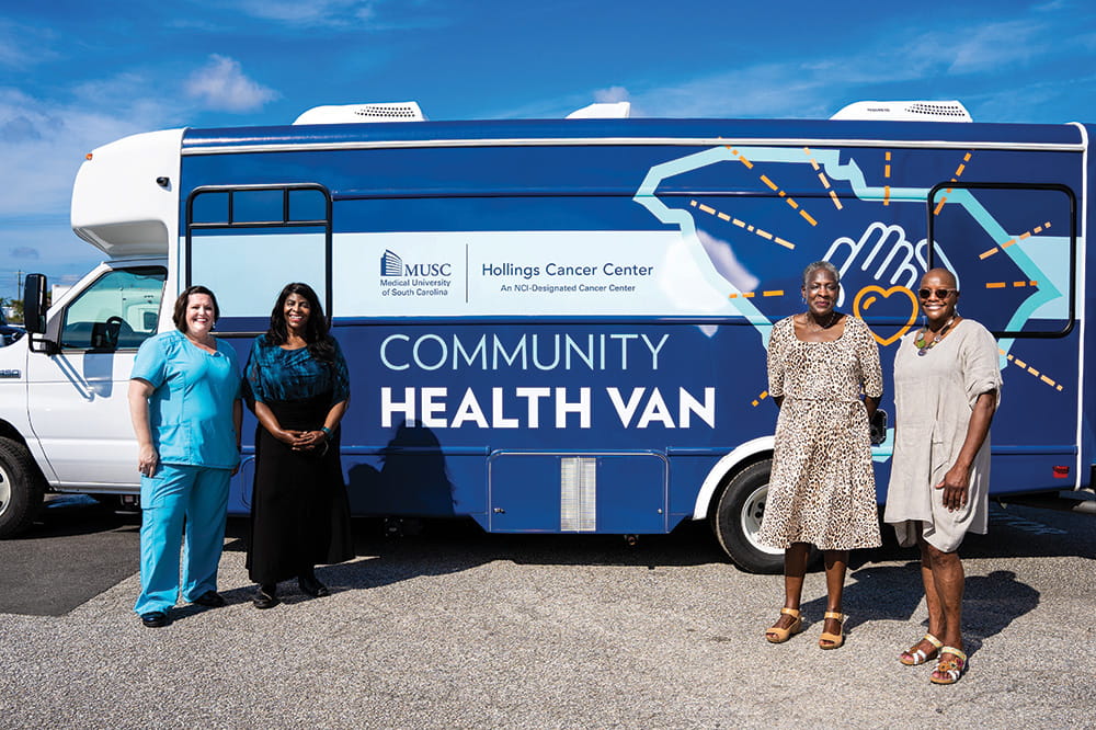four women stand in front of the Hollings Cancer Center Community Health Van