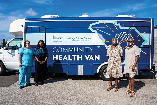 four women stand in front of the Hollings Community Health Van
