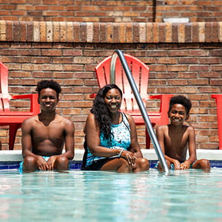 LaToya Wilson sits with her sons at the edge of a pool