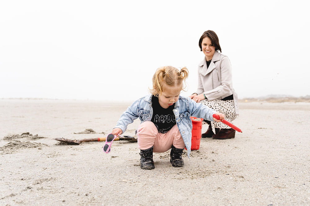 Liza Patterson watches while her daughter plays in the sand