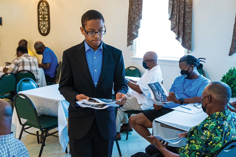 a young man passes out handouts at a prostate cancer awareness event