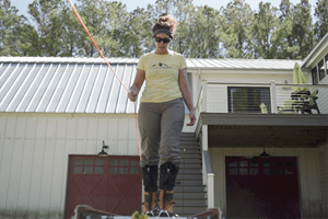 screenshot of Cokie Cox walking on a ladder while holding onto a rope
