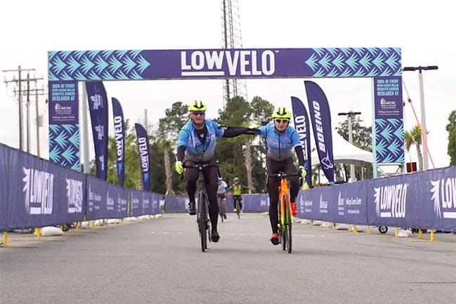 screenshot of two people riding in Lowvelo with their hands on each other's shoulders