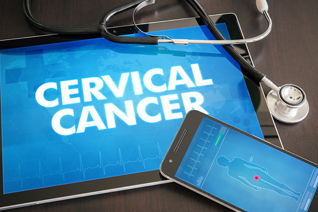 a stethoscope sits on top of a tablet that says cervical cancer on the screen