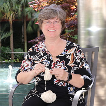 Christy Crouch sits outside with knitting in her lap