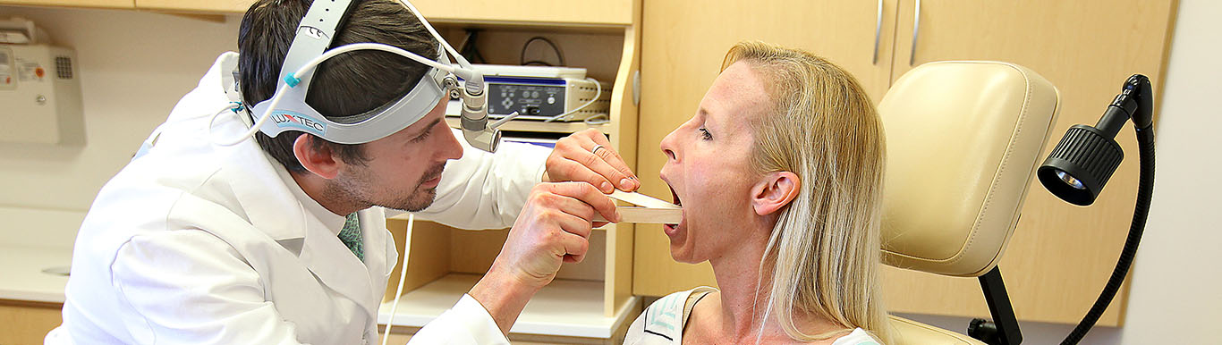 Dr. Evan Graboyes examines the mouth of a patient