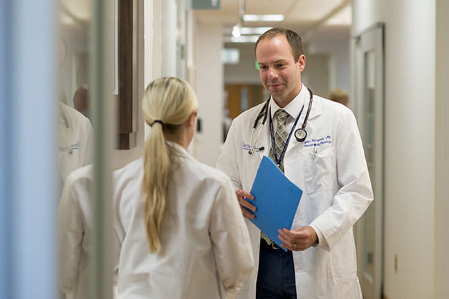Dr. John Kaczmar talks with a colleague