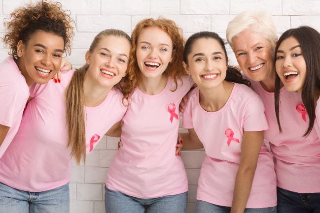 A group of women wearing pink breast cancer awareness ribbons