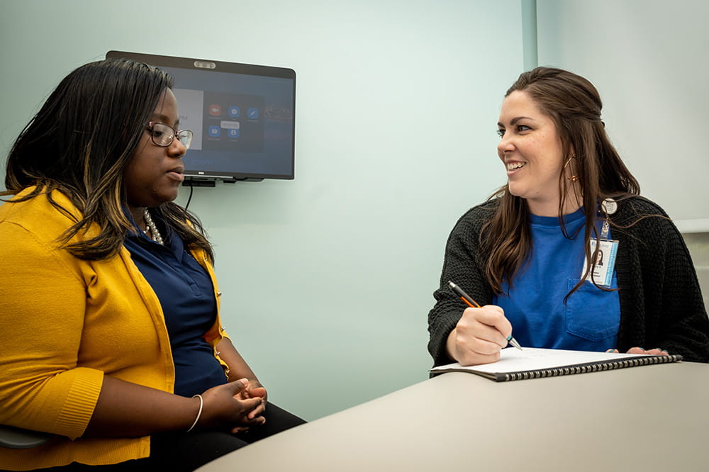 two women sit at a table reviewing test results