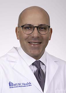 headshot of Dr. Kevin Roggin in white coat