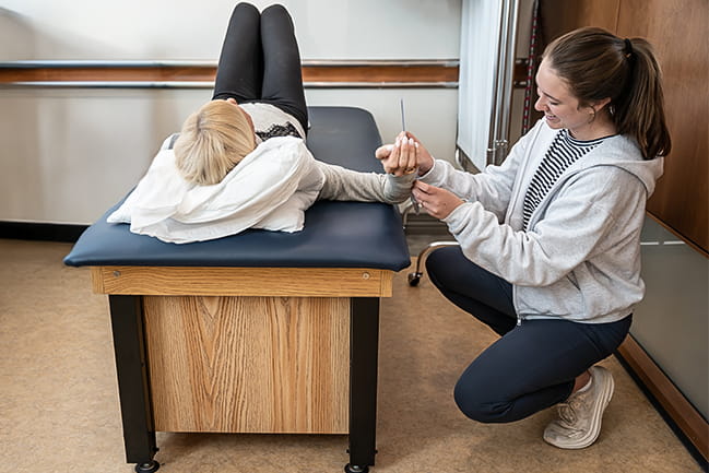 occupational therapist working with patient on table