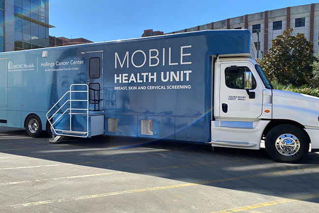 Hollings Cancer Center Mobile Health Unit van parked in parking lot