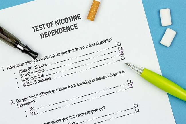 nicotine dependence questionnaire with pen, cigarette, vape pen and nicotine gum