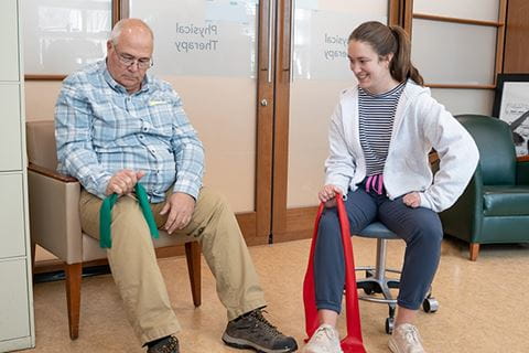 an occupational therapist does resistance band exercises with a patient