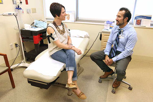 Courtney Nelson visits with her surgical oncologist Dr. Virgilio George. When Nelson was diagnosed with stage 2 colon cancer, George ended up removing one-third of her colon. Photo by Sarah Pack