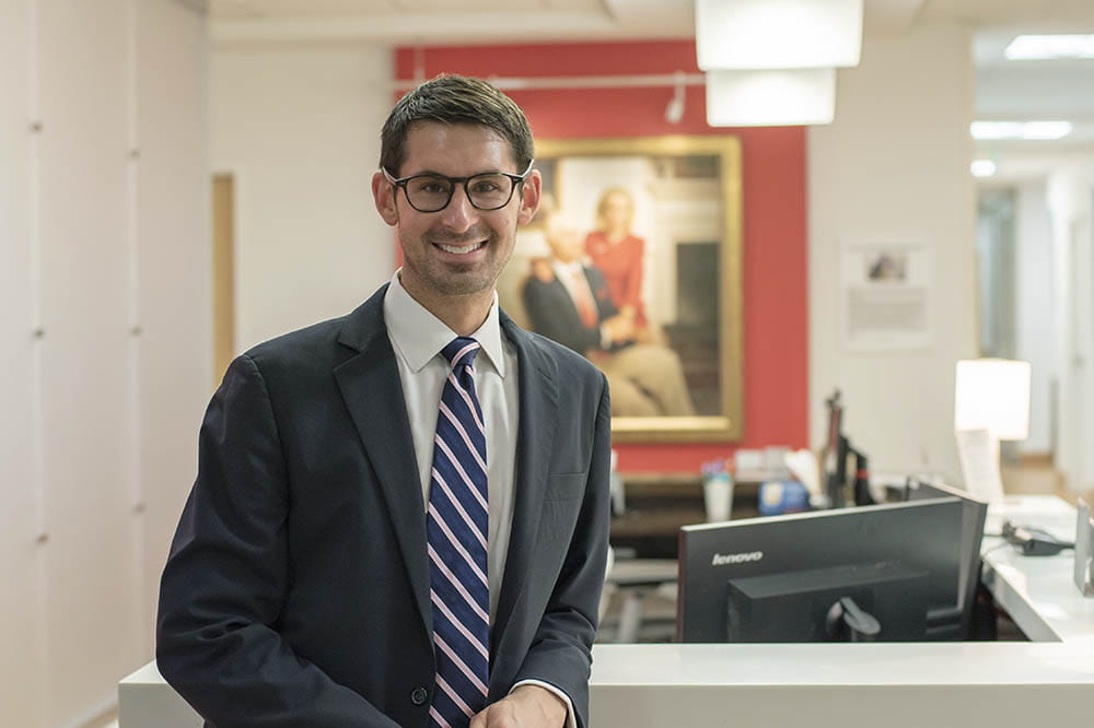 Evan Graboyes, M.D., stands next to a desk