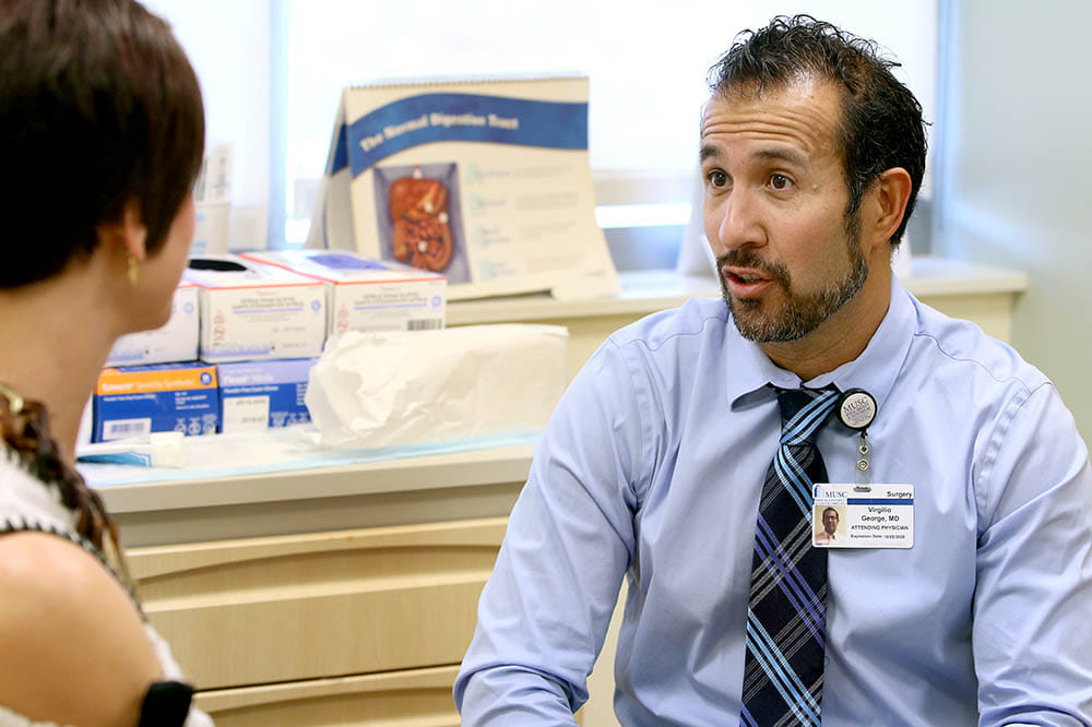 Virgilio George, M.D., talks with a patient