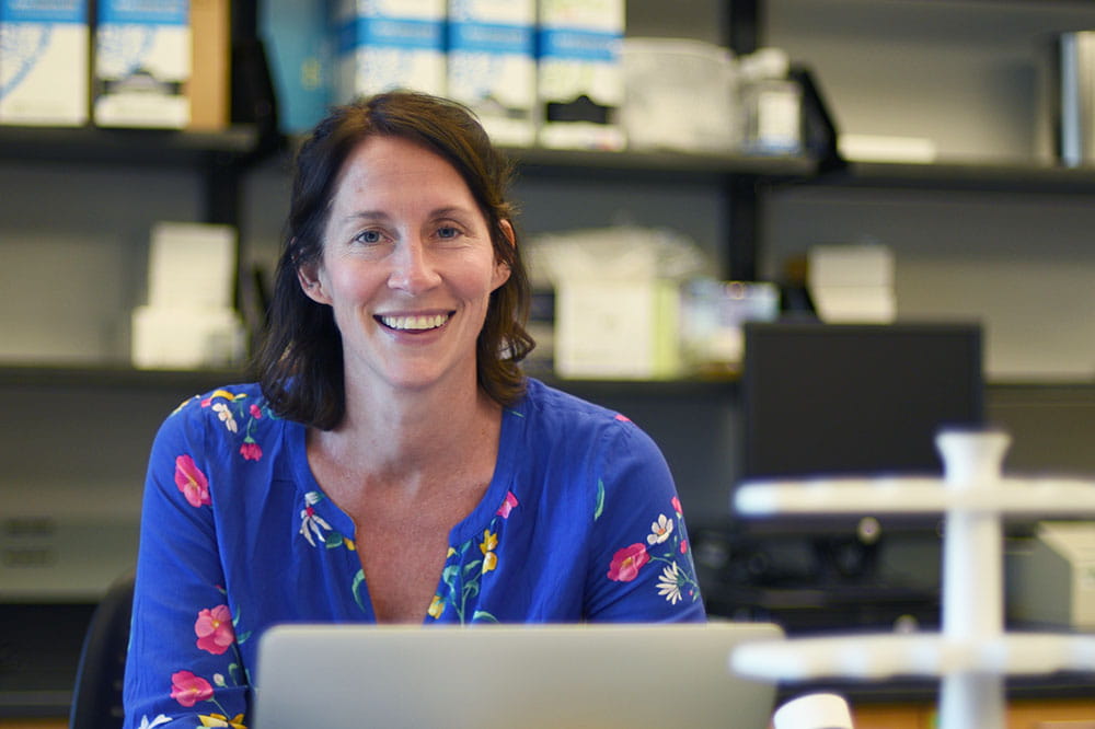 Dr. Jessica Thaxton works on a laptop in her lab
