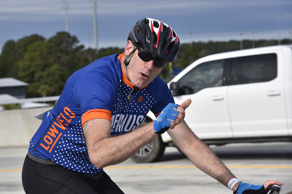 Dr. Denis Guttridge gives a thumbs up while riding his bike in Lowvelo 2019