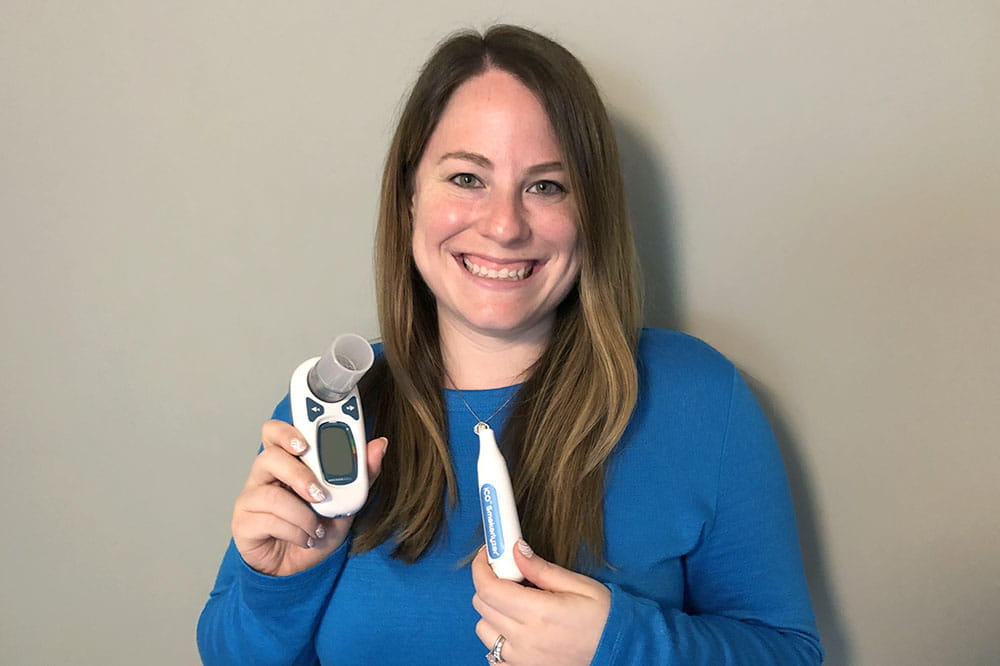 Jennifer Dahne holds smartphone-enabled devices used in remote clinical trials