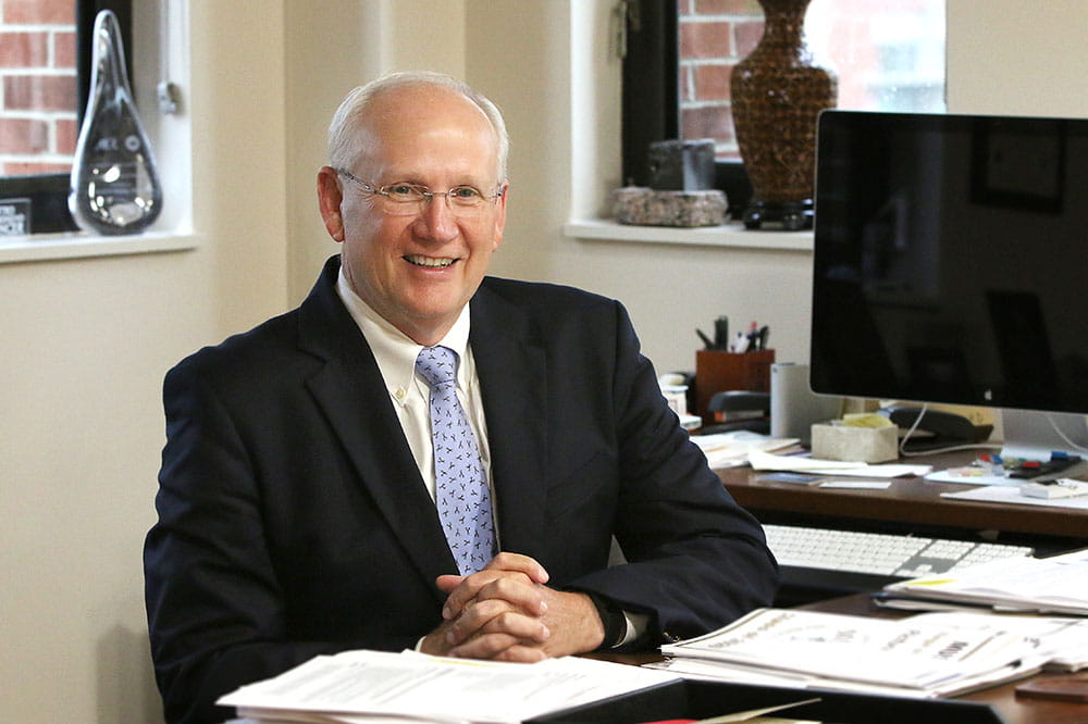 Dr. Raymond DuBois sits at his desk in his office