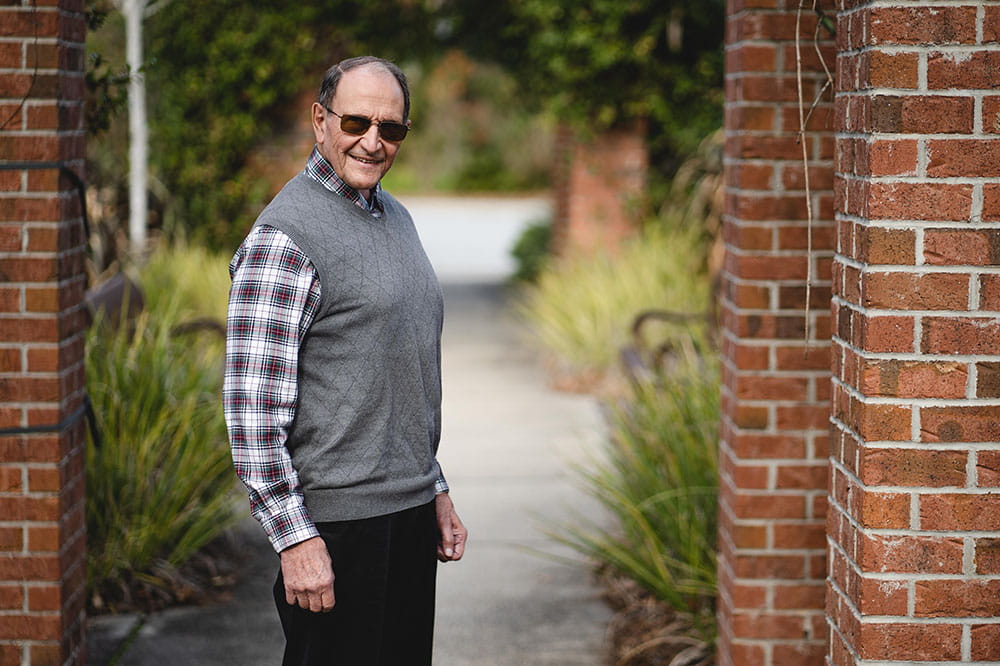 Tony Pesavento stands outside with a garden path behind him