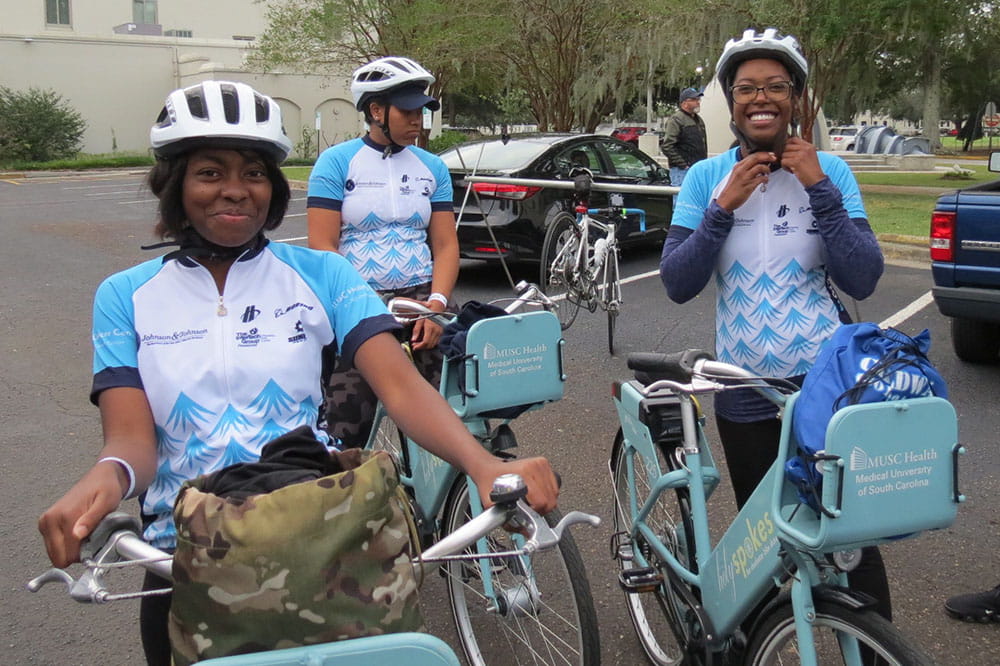 Three women stand with their bikes as they prepare to ride in Lowvelo 2019