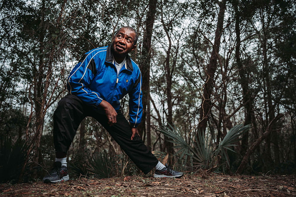 Lee Moultrie stretches his legs before a walk on a wooded path