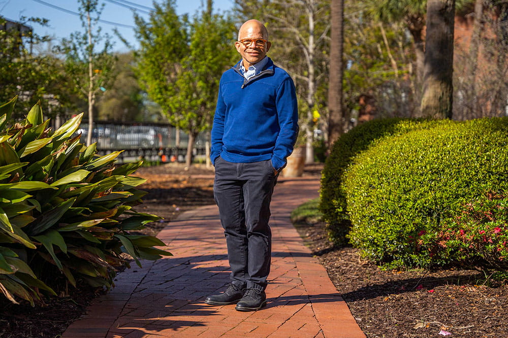Dr. Craig Lockhart stands outside on a brick path