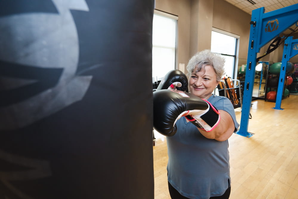 MUSC Hollings’ Survivors’ Fit Club member Joann Baldwin punches a heavy bag during a training session.