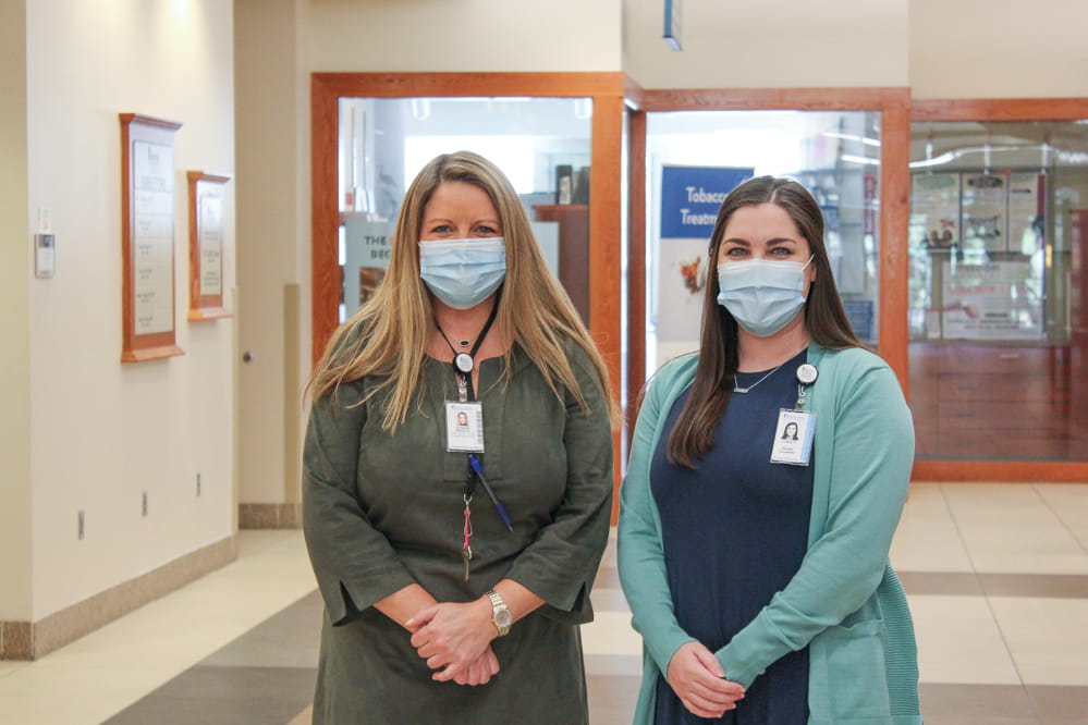 Genetic counselors Libby Malphrus (left) and Charly Harris pose for a photo in the main hallway of MUSC Hollings Cancer Center March 17, 2021. Photo by Kelsey Hudnall