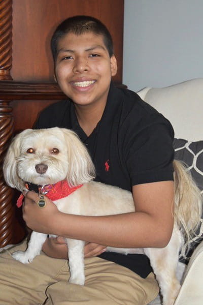 Weston Mallard holds a dog in his lap