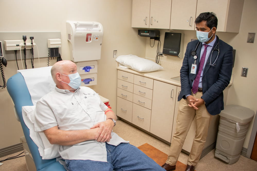 James Deer talks with Dr. Baratam in an exam room