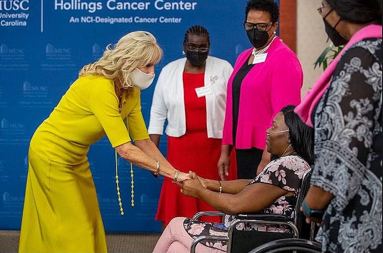 First lady Dr. Jill Biden shakes hands with breast cancer survivor LaToya Wilson while several others look on