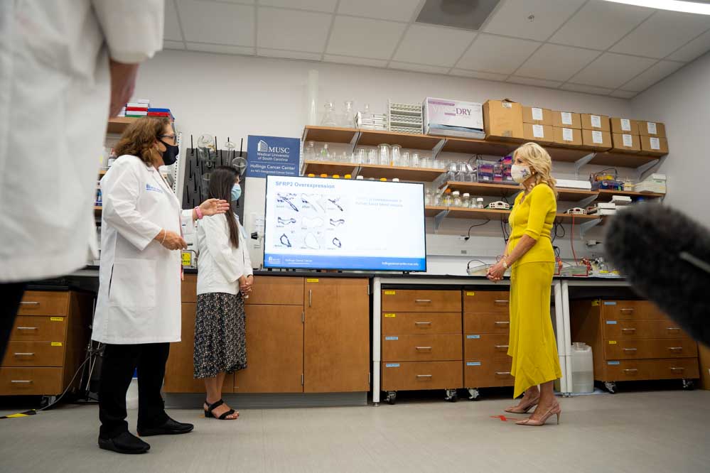 Dr. Nancy Klauber-DeMore and Ingrid Bonilla give a presentation about breast cancer research while first lady Dr. Jill Biden looks on