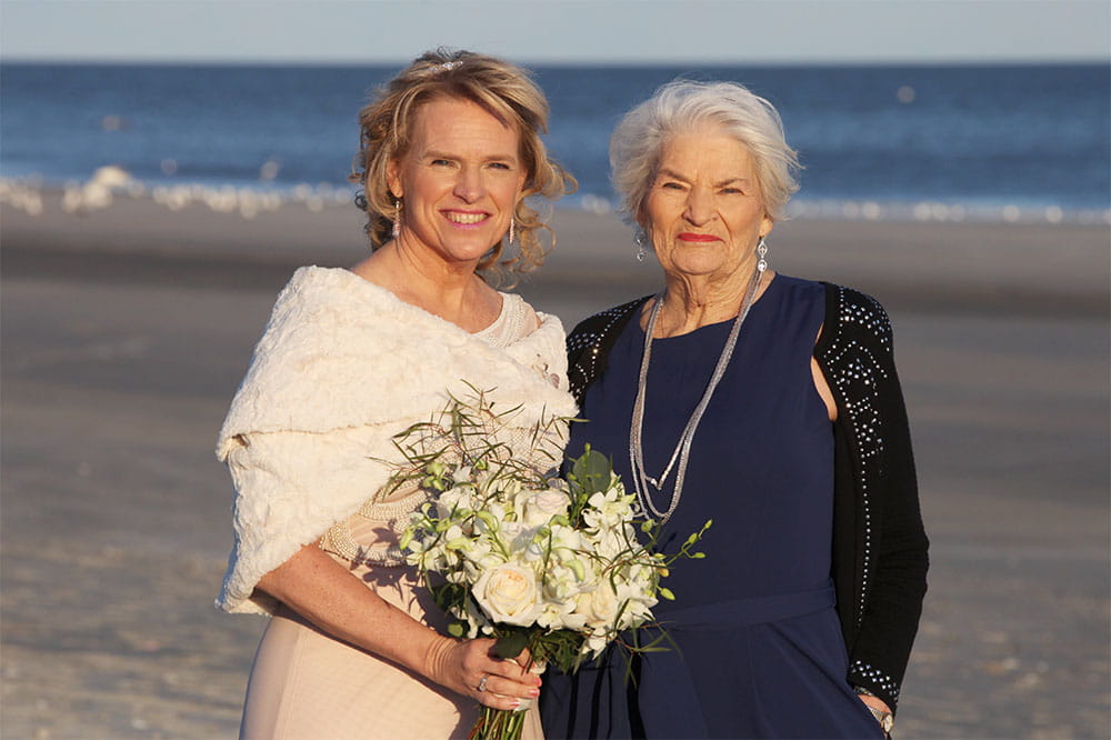Dawn Brazell in her wedding dress on the beach with her mom Sara Cutler