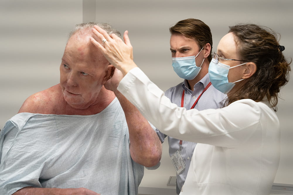 two doctors examine the back of a man's head