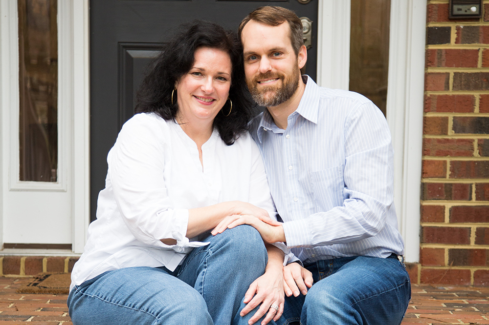portrait of a couple sitting on the front steps of their house