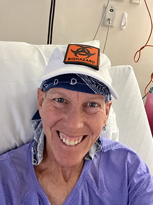 a woman in a hospital bed with a baseball cap that says radioactive