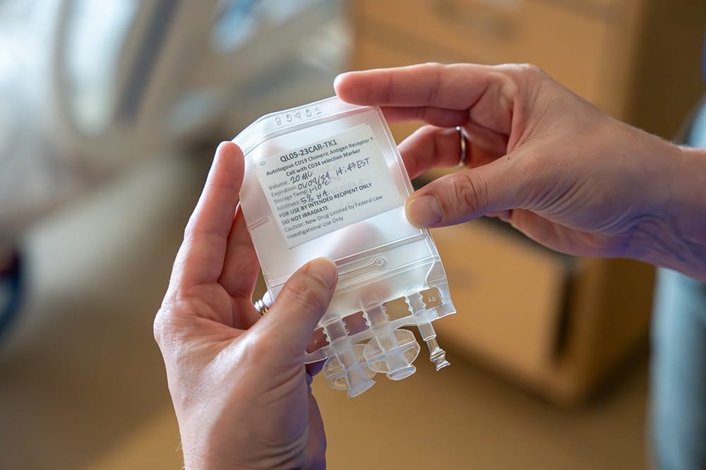 closeup of a small IV bag that indicates it contains an investigational drug intended for one individual