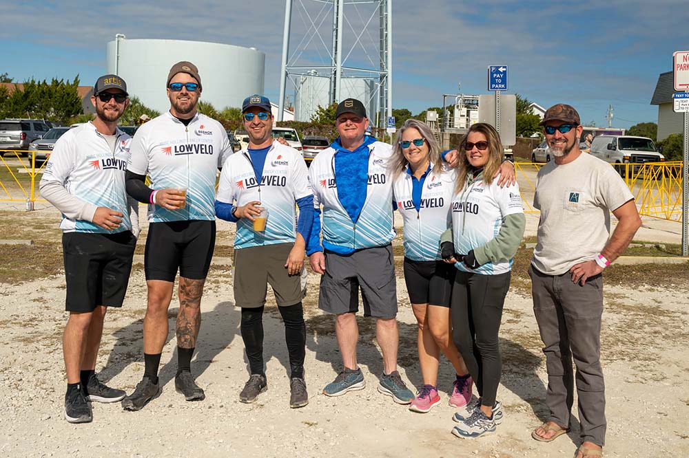 a group of people in Lowvelo jerseys pose for a photo after the ride 