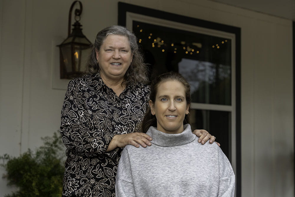 mother and daughter pose on a porch