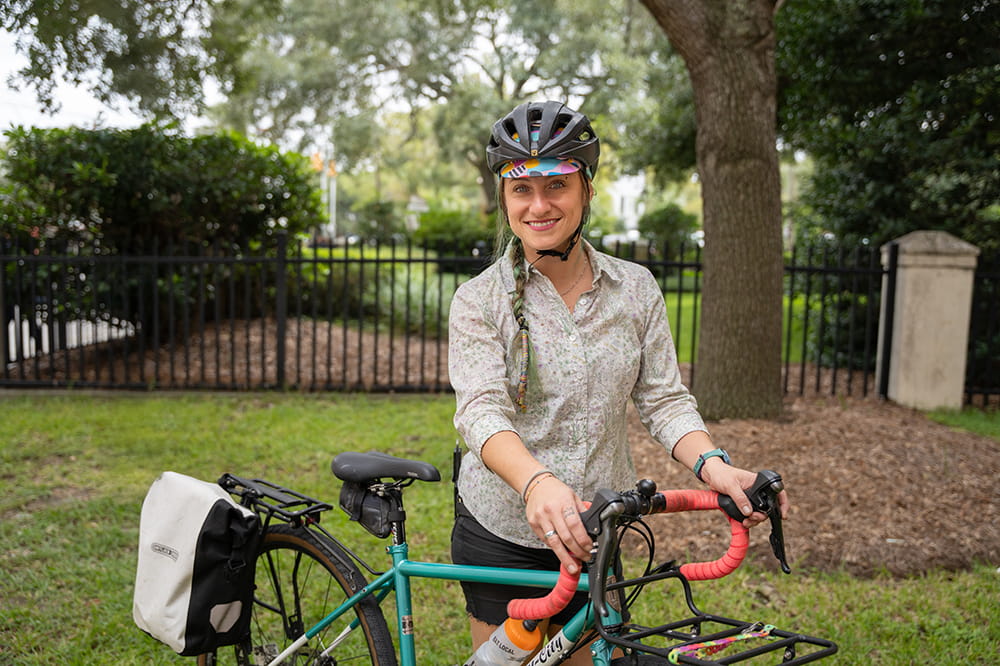 a woman poses with a bike